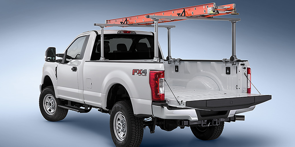 Ford Super Duty pickup at a construction site with a ladder mounted on a rack.